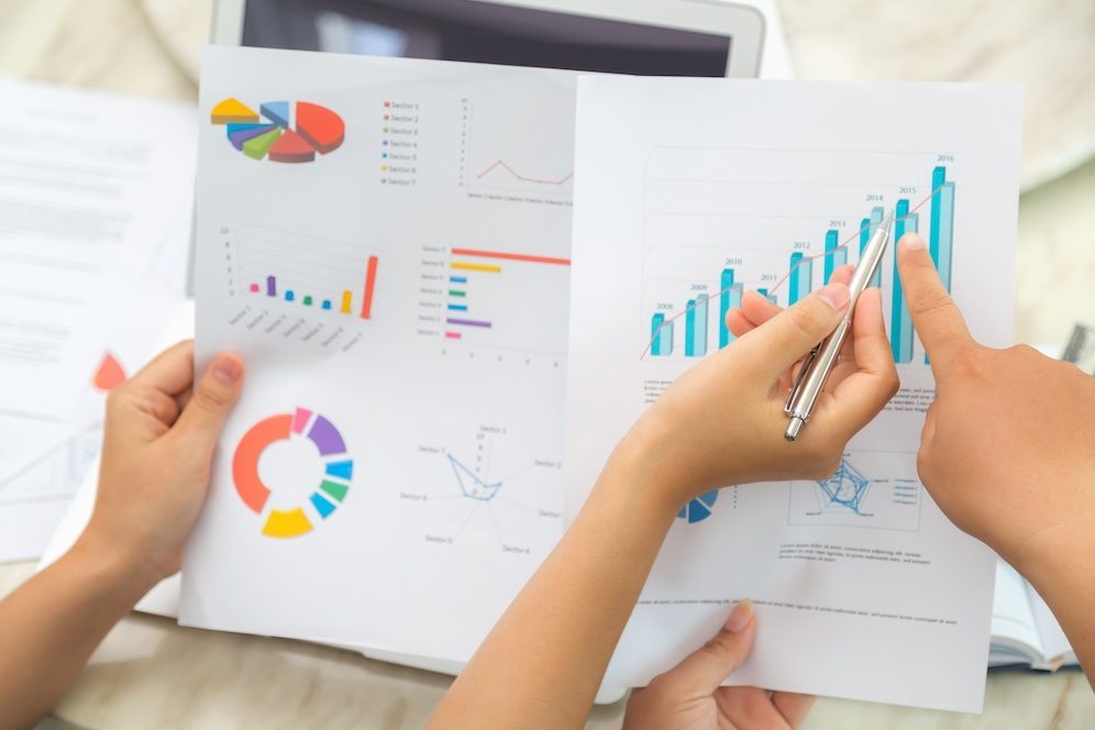 Group of business people pointing at business document during meeting